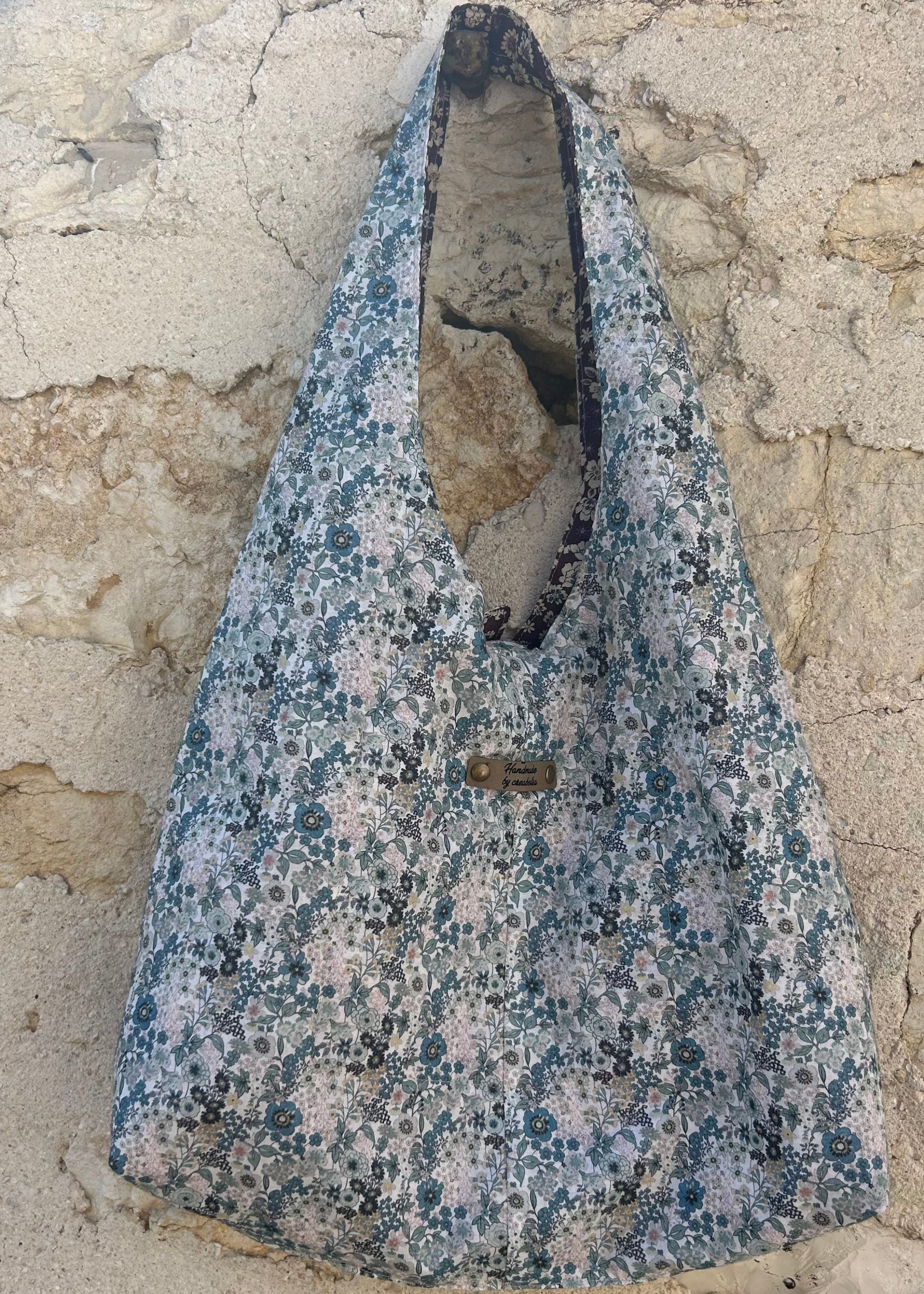 Sac hobo réversible en tissu Liberty fleuri bleu, création artisanale fait main par Creabolsa.